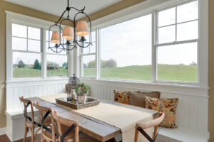 A bright dining area with large double-hung windows and a single picture window.